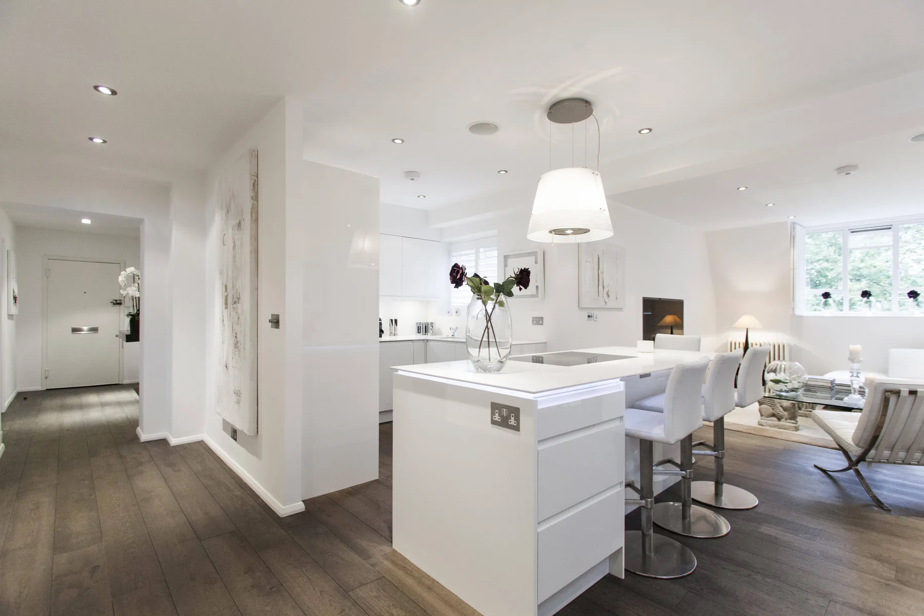 A bright open-plan kitchen and dining area with a central island and seating.