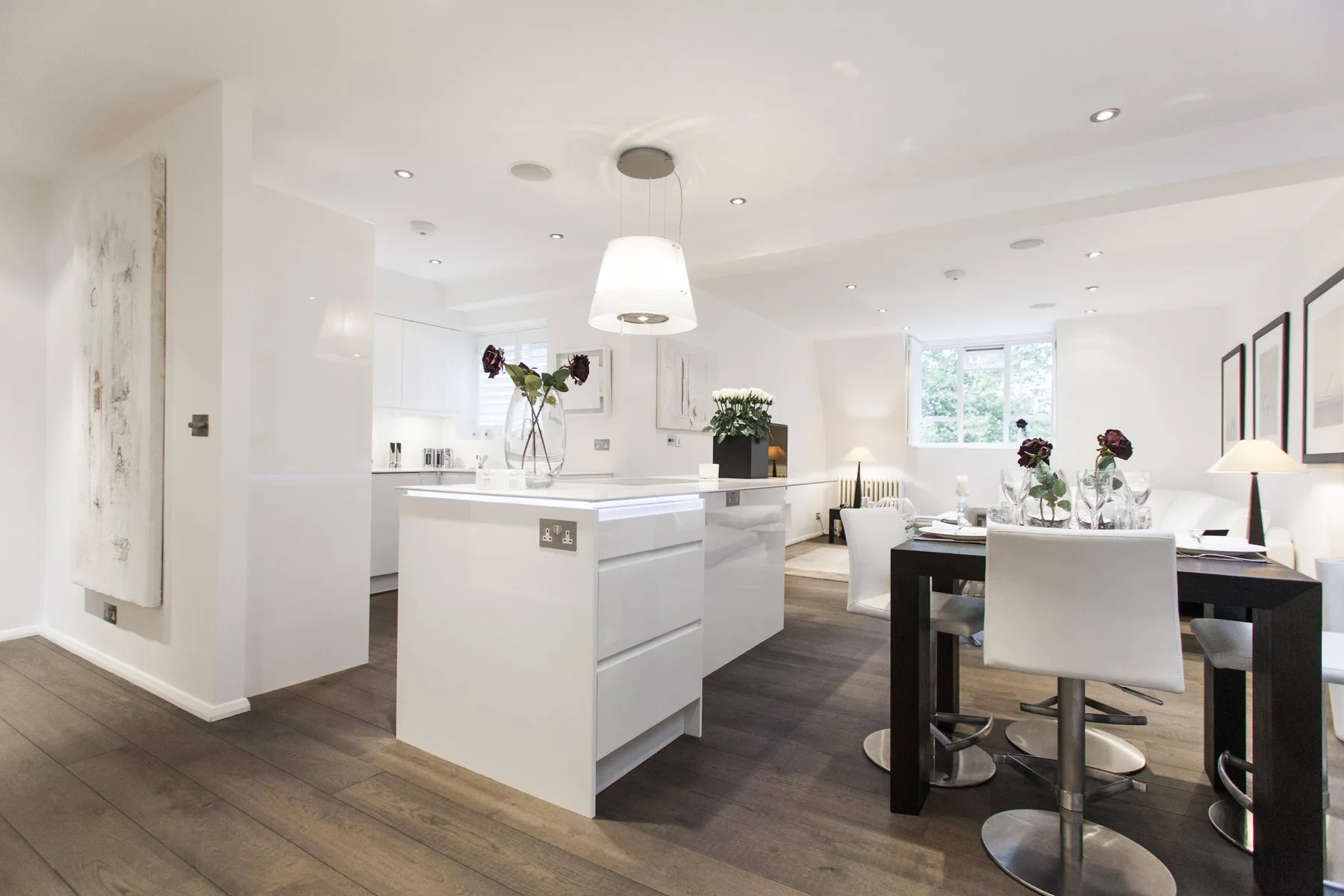 Una luminosa cocina-comedor de planta abierta con una isla central y una mesa de comedor.