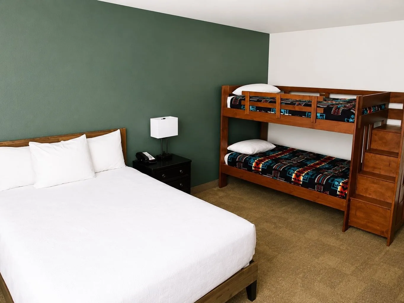 Family Suite with queen bed and wooden bunk beds against green accent wall