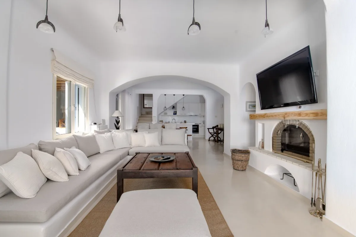 A bright living room with seating, a coffee table, and a fireplace.