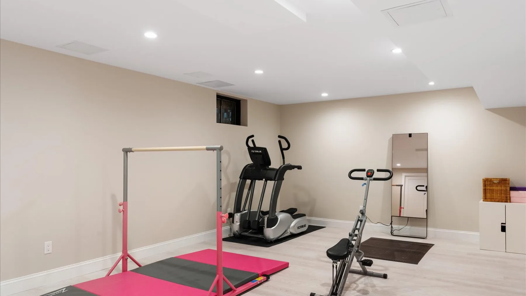 Una sala de ejercicio luminosa cuenta con cintas de correr y otros equipos de entrenamiento.