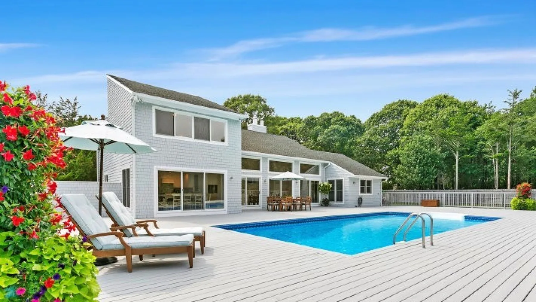 Una casa moderna da a una piscina y una amplia terraza.