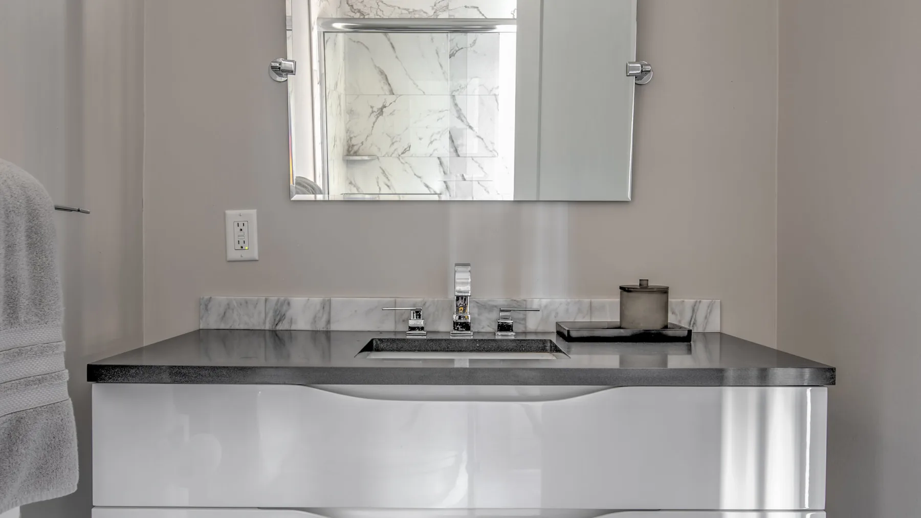 Un lavabo de baño con fregadero, encimera y espejo.