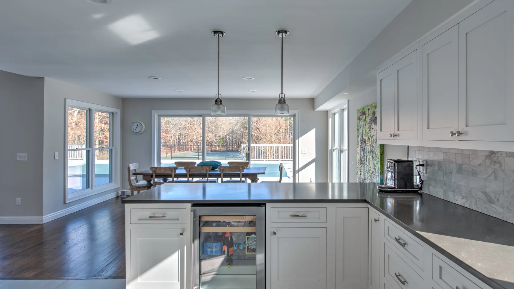 Una cocina luminosa con una isla y ventanas con vistas a una zona arbolada.