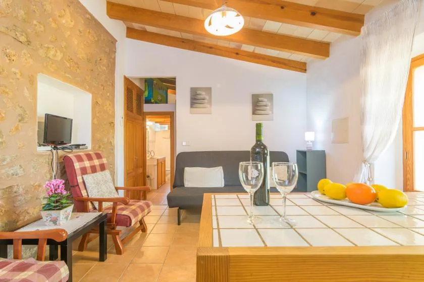 A living and dining area with a table set with glasses and fruit.