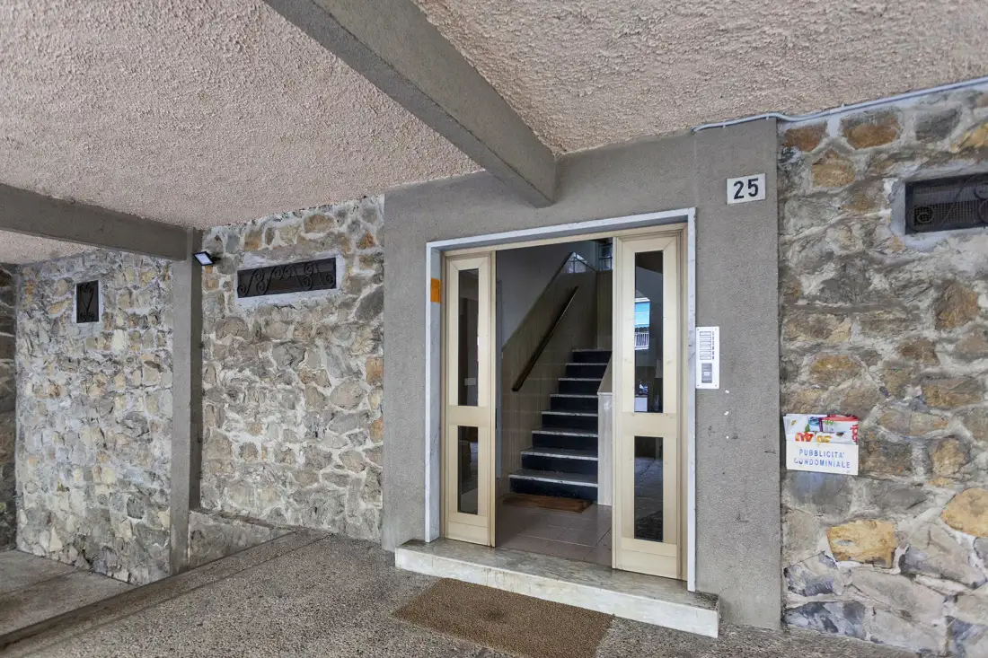 An entrance with glass doors opens onto an interior staircase.