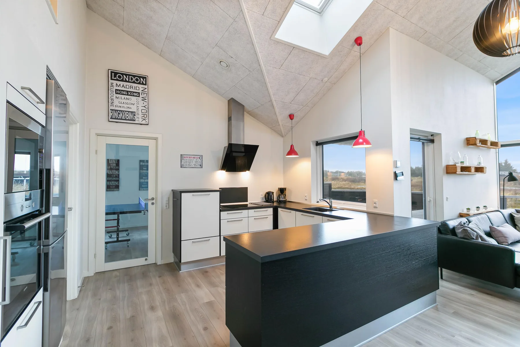 Una cocina luminosa con una gran isla y una zona de estar contigua.