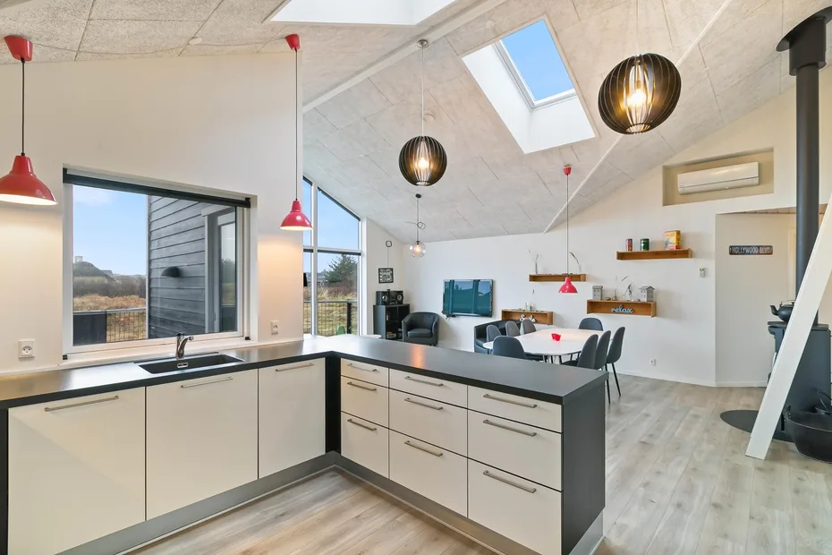 Una luminosa cocina-comedor de concepto abierto con isla y tragaluz.