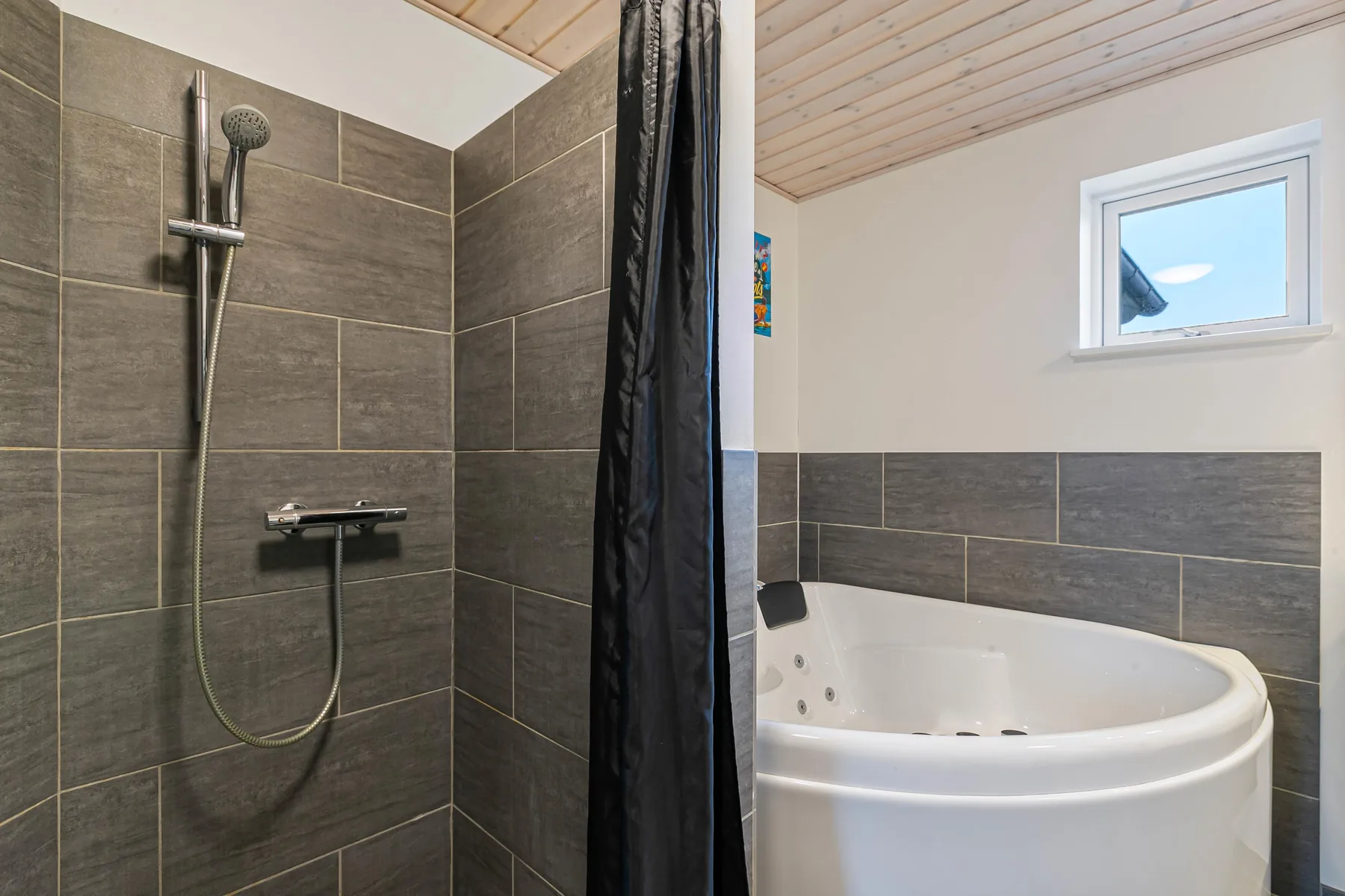 Un baño con ducha de azulejos y una bañera blanca.