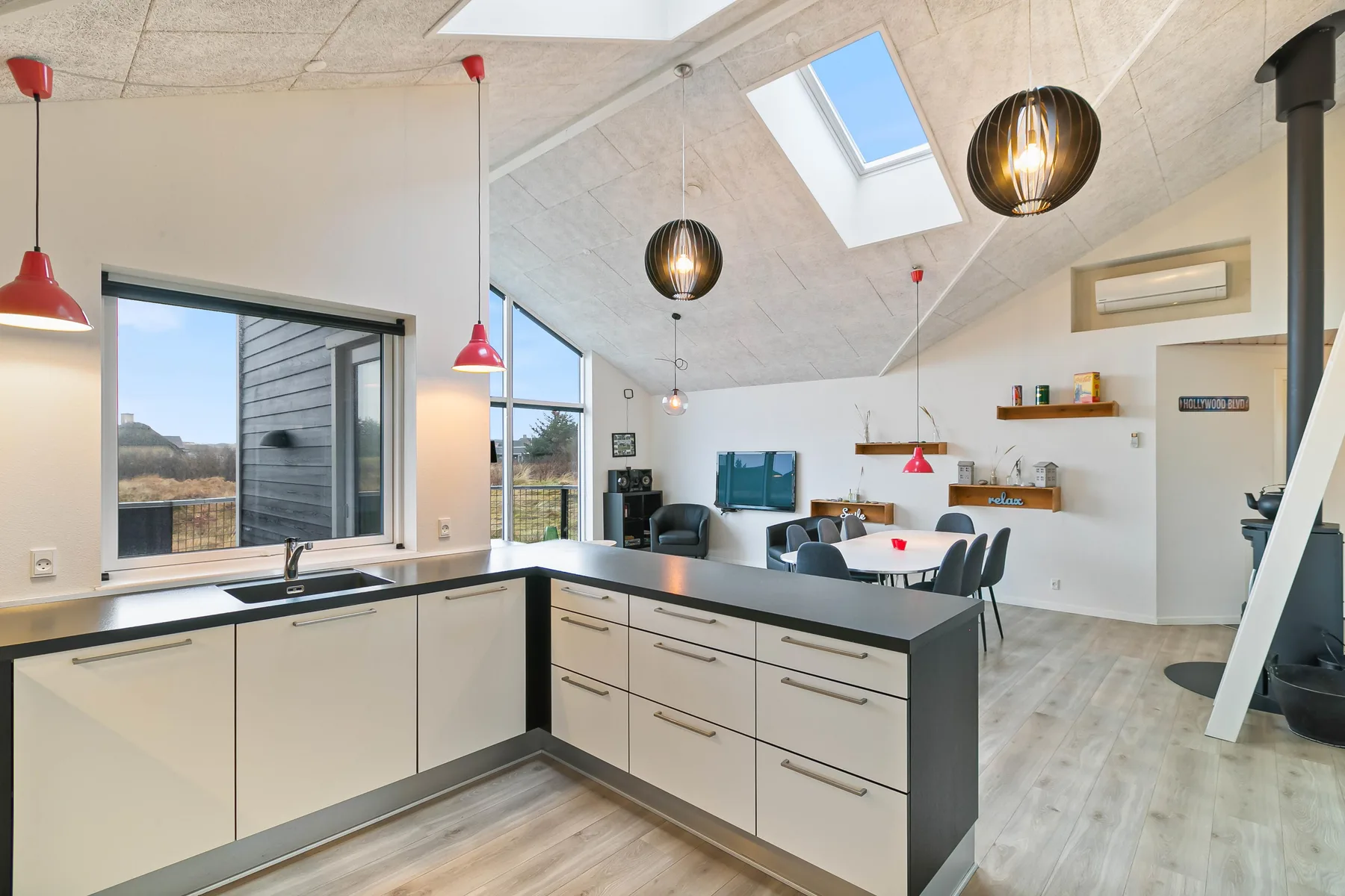 Cocina y sala de estar de planta abierta con una isla central y una claraboya.