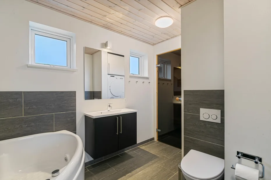Un baño con bañera, lavabo y sanitario.