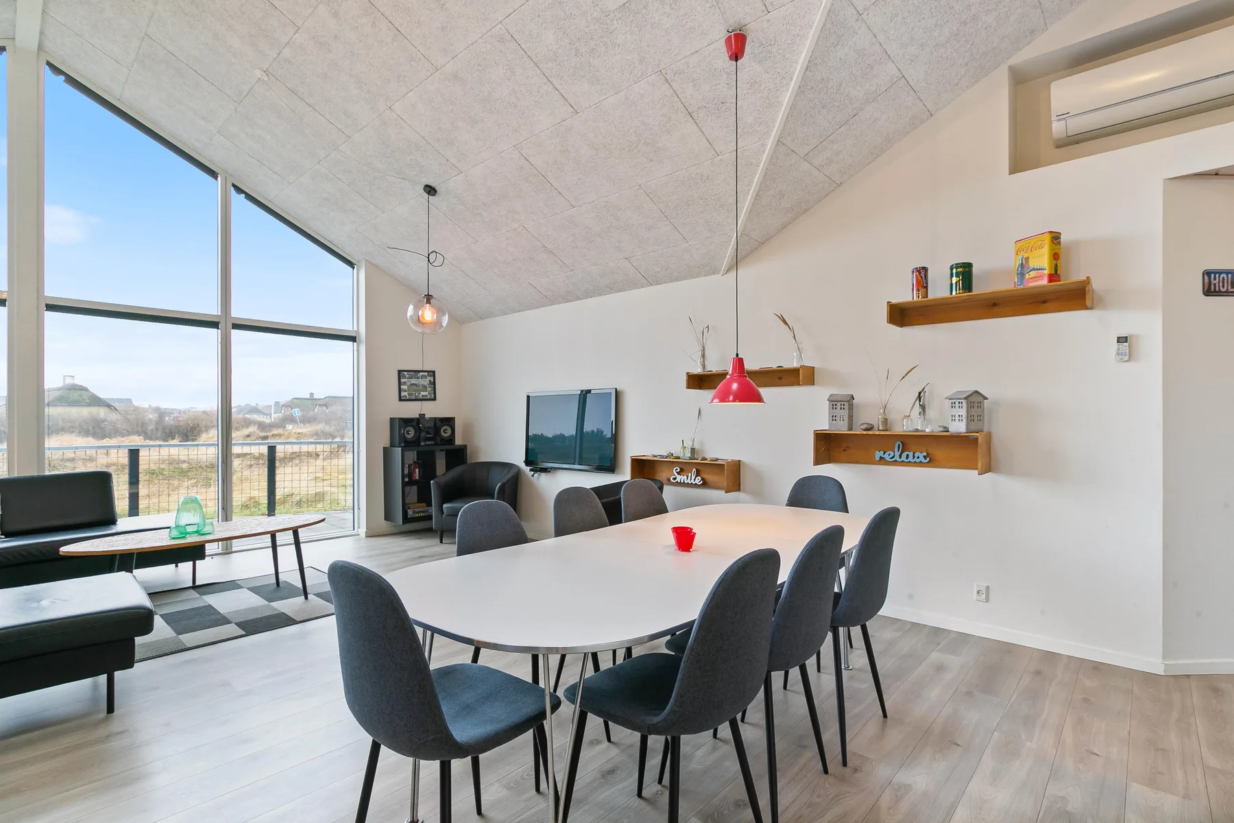 Una luminosa sala de estar y comedor con grandes ventanas y una mesa de comedor.