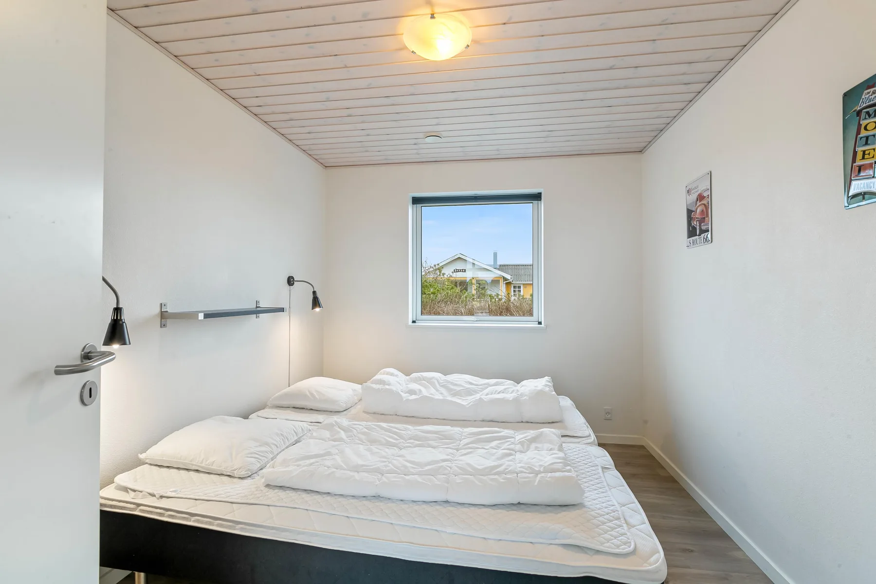 Un dormitorio con una cama debajo de una ventana.
