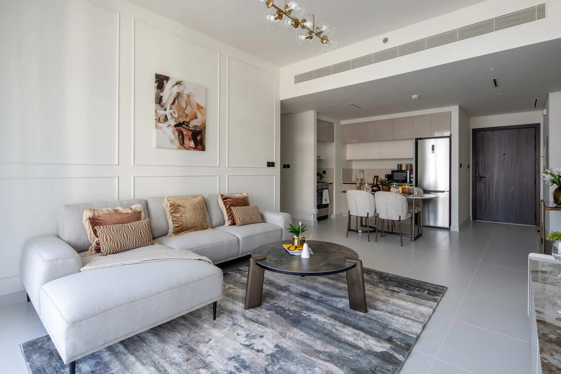 Una sala luminosa con una zona de asientos y una cocina abierta.