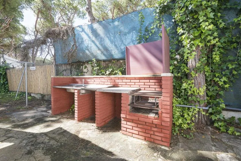 An outdoor brick barbecue area with a built-in grill and preparation counter.