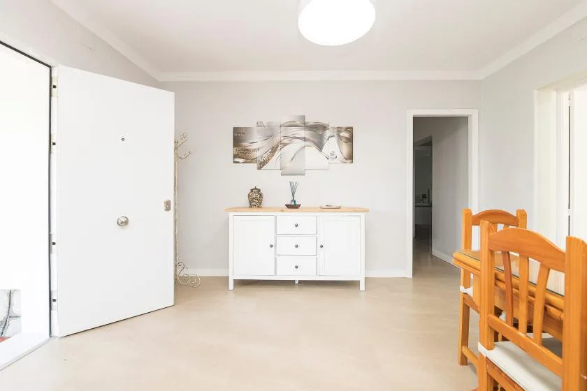 A bright interior entry area with a white console beneath a wall picture.