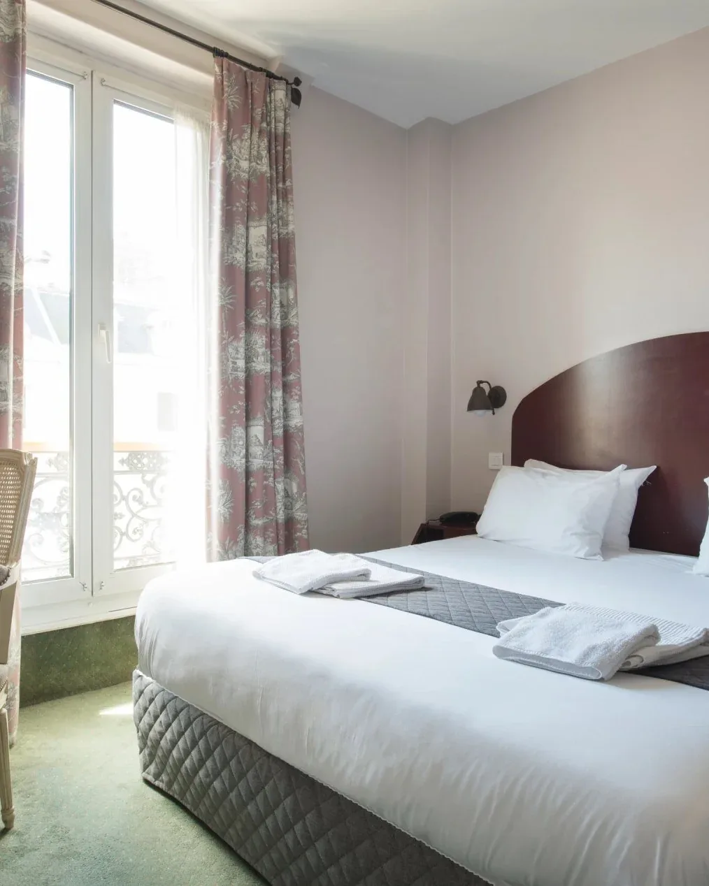 Habitación de hotel con una cama doble y un sillón.