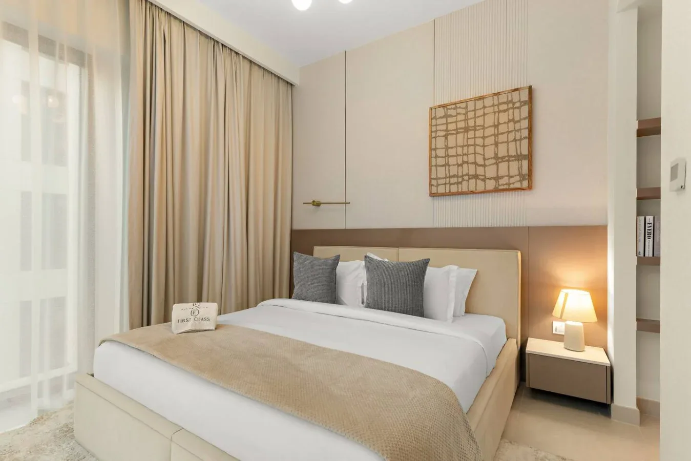 A bedroom with a neatly made bed and curtains along the window.