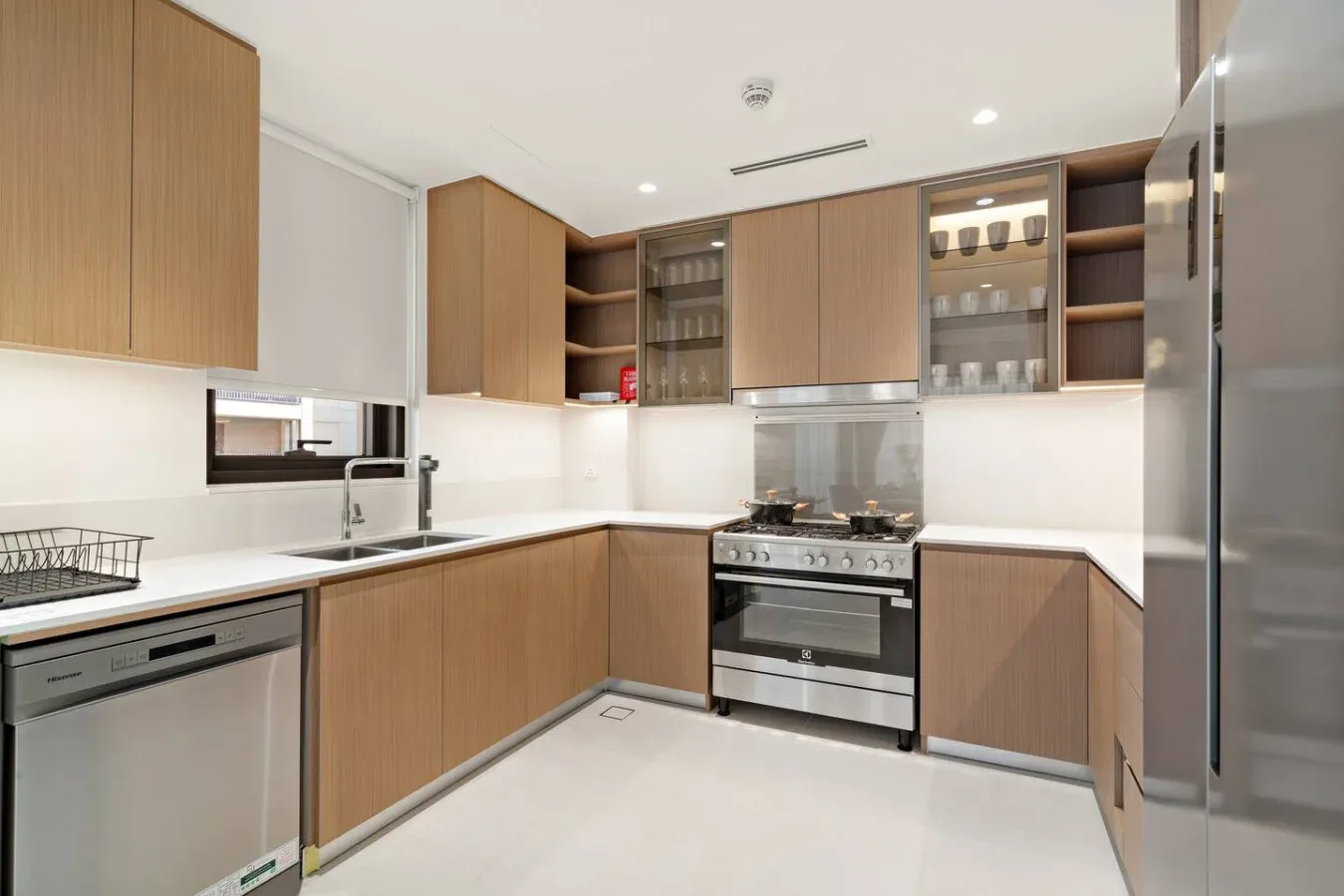 A modern kitchen with wood cabinets, a stove, and stainless steel appliances.