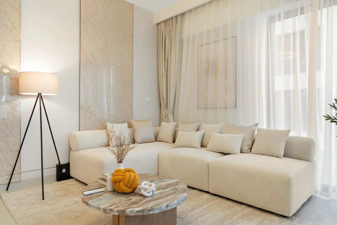 A bright living room with a sectional sofa and a round coffee table.