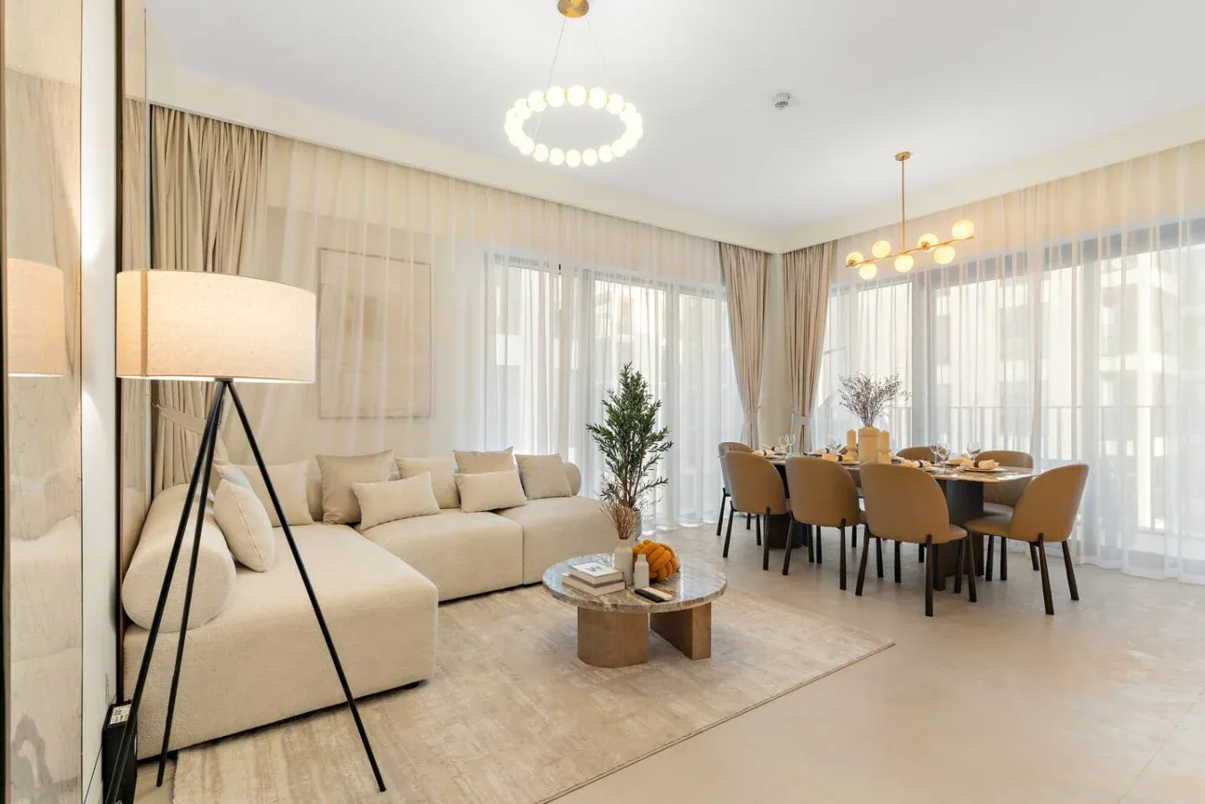 A bright living and dining area with seating around a coffee table and dining table.