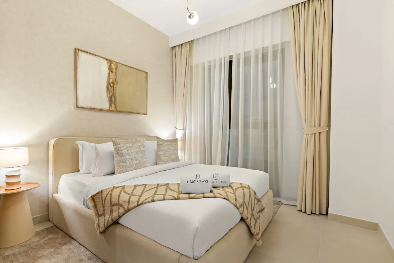 A bedroom with a bed and floor-length curtains covering a large window.