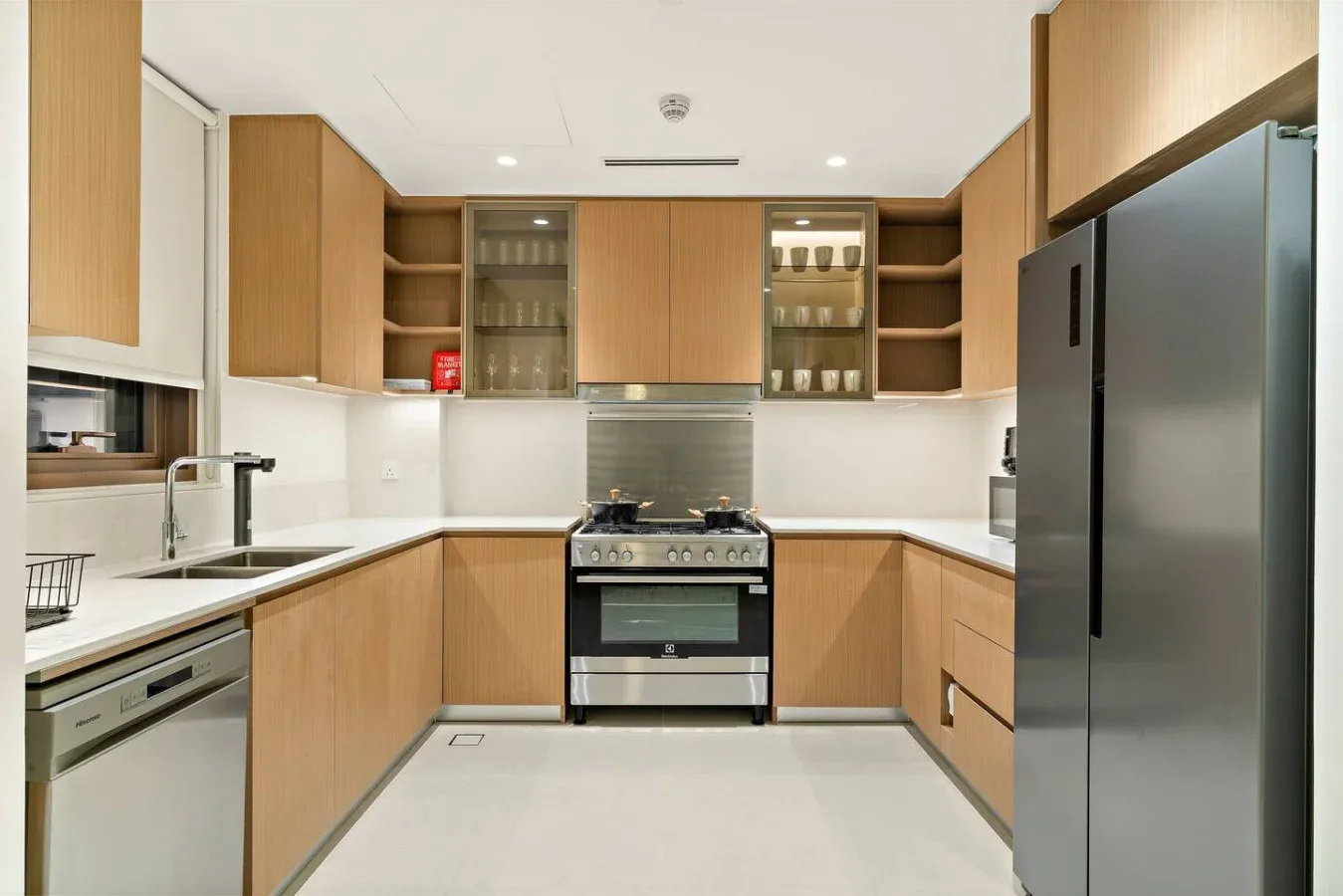 A kitchen with wood cabinets, a stove, and a large refrigerator.