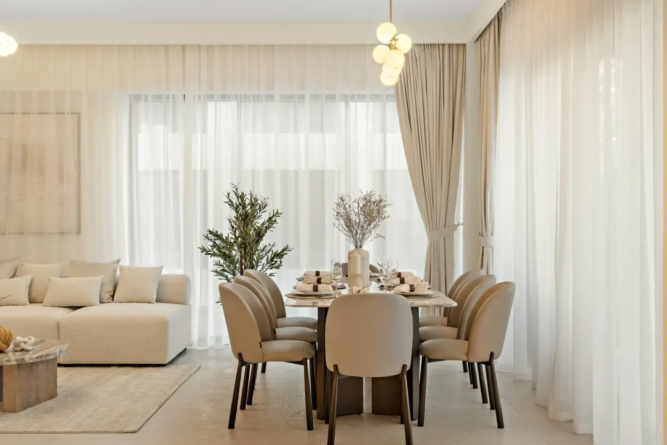 A dining area with a table and seating beside a bright living room.