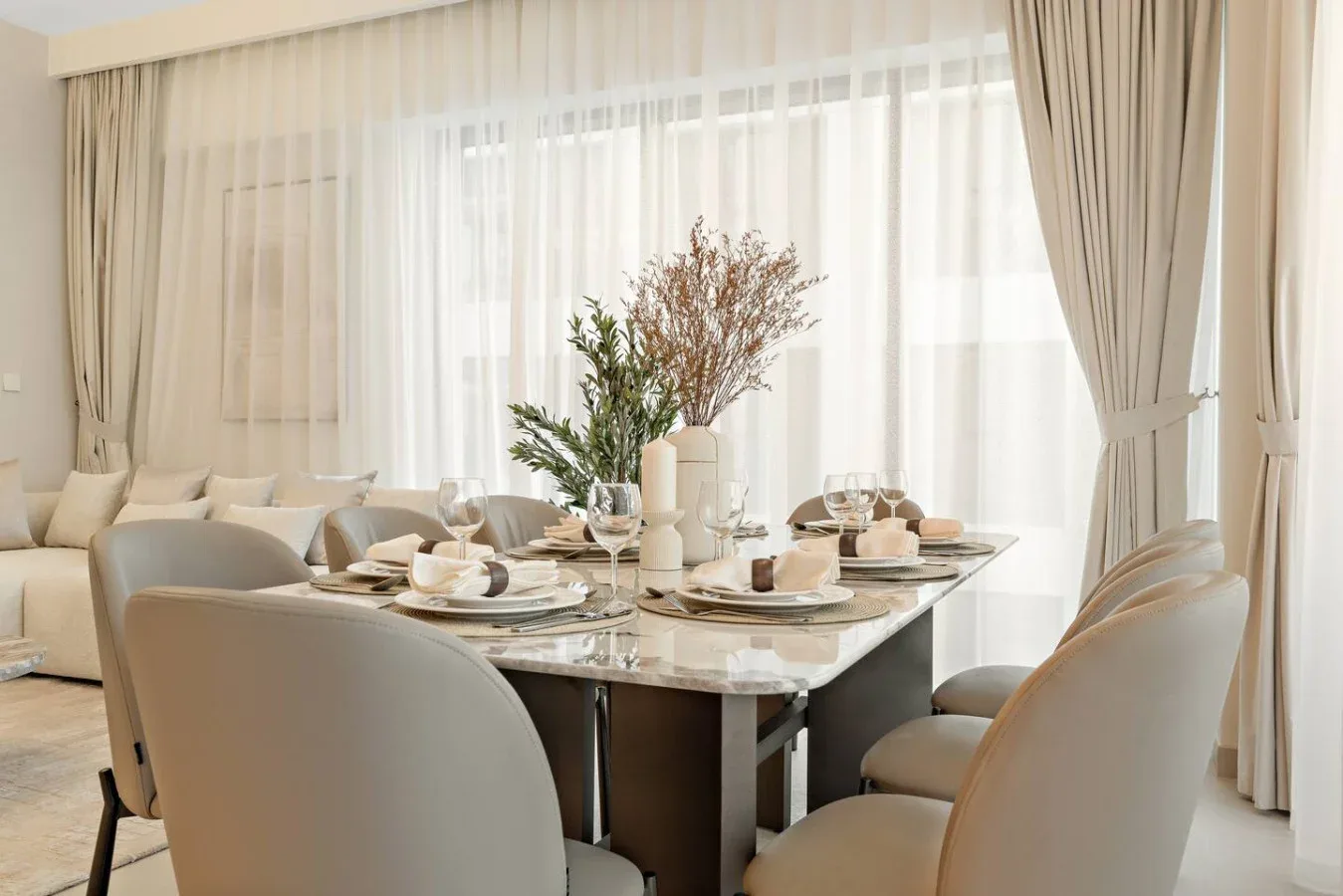 A dining area with a table set for a meal beside a bright window.