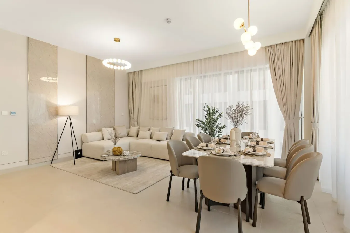 A bright open-plan living and dining area with a sectional seating area and dining table.