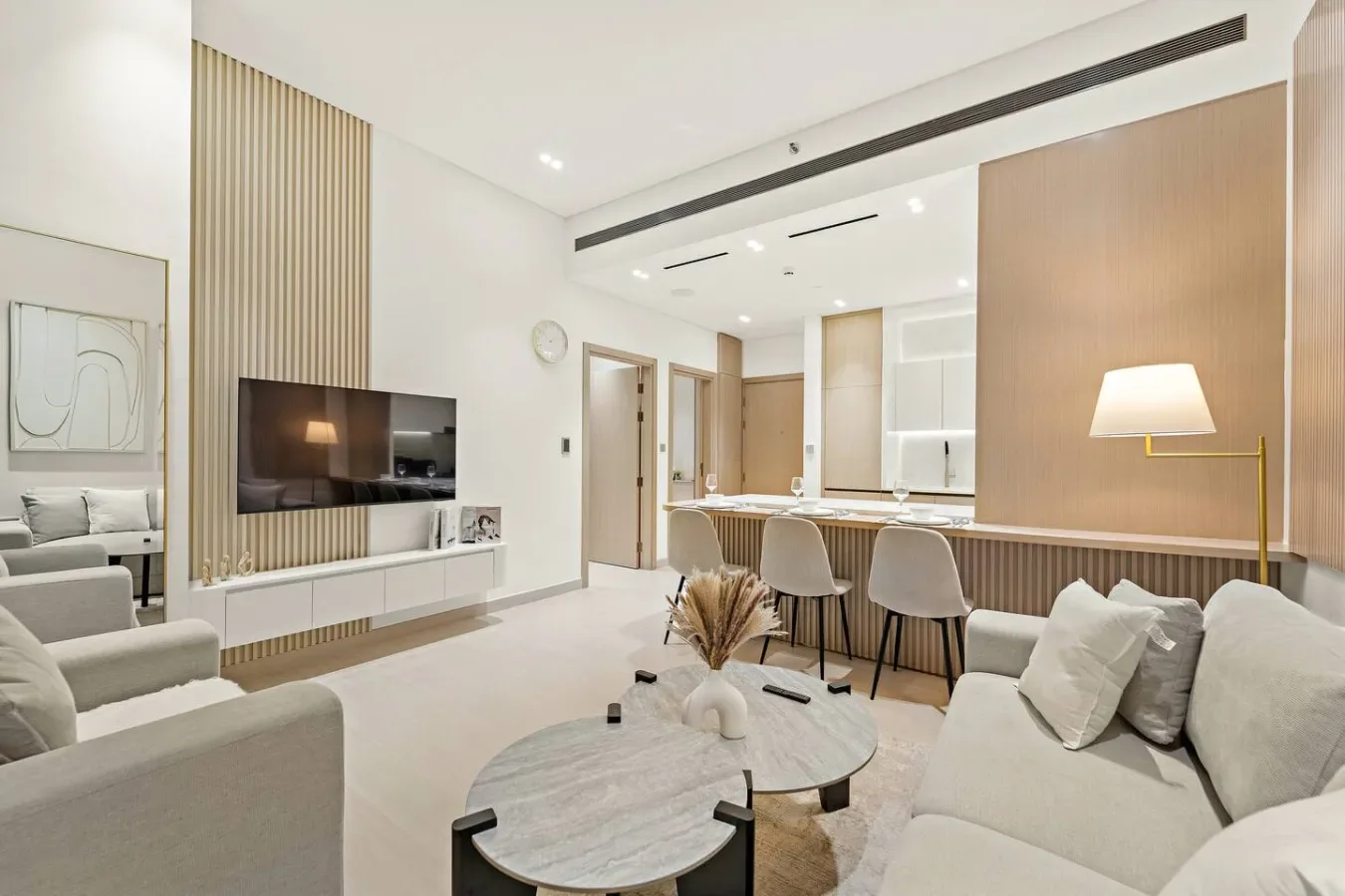 A bright living room with seating, a television, and a dining area.