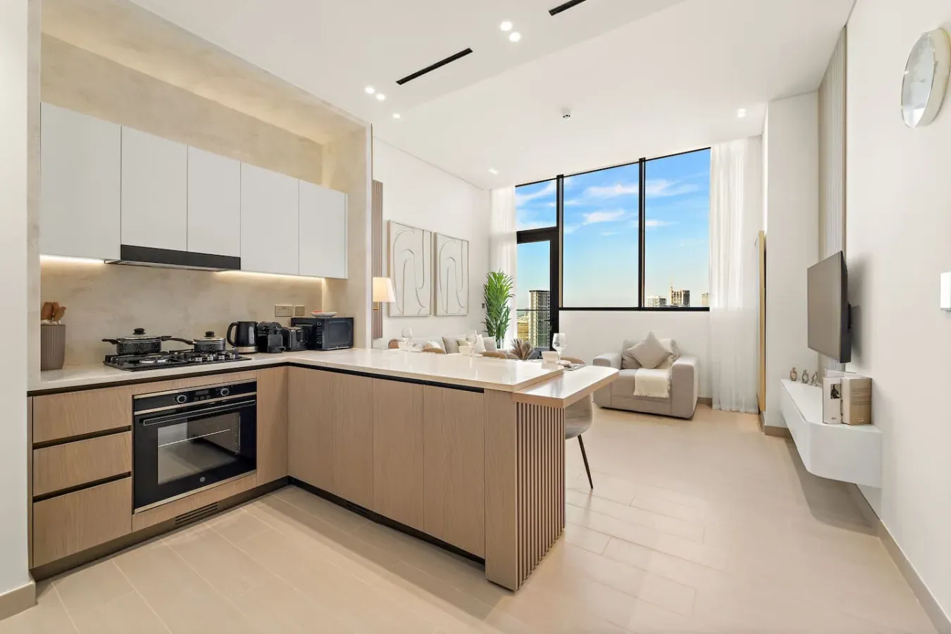 A modern open-plan kitchen and living area with large windows and a sofa.