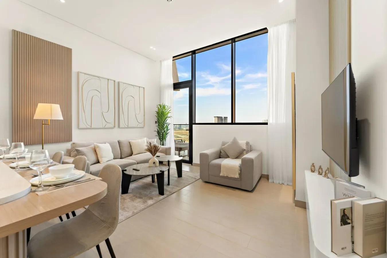 A bright living room with a dining area, seating, and large windows.