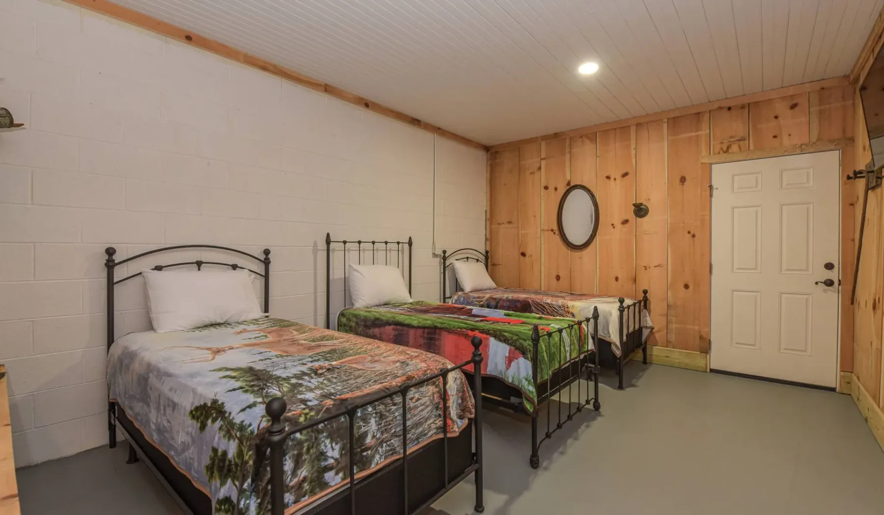 A bedroom with several metal-framed beds and colorful patterned bedding.