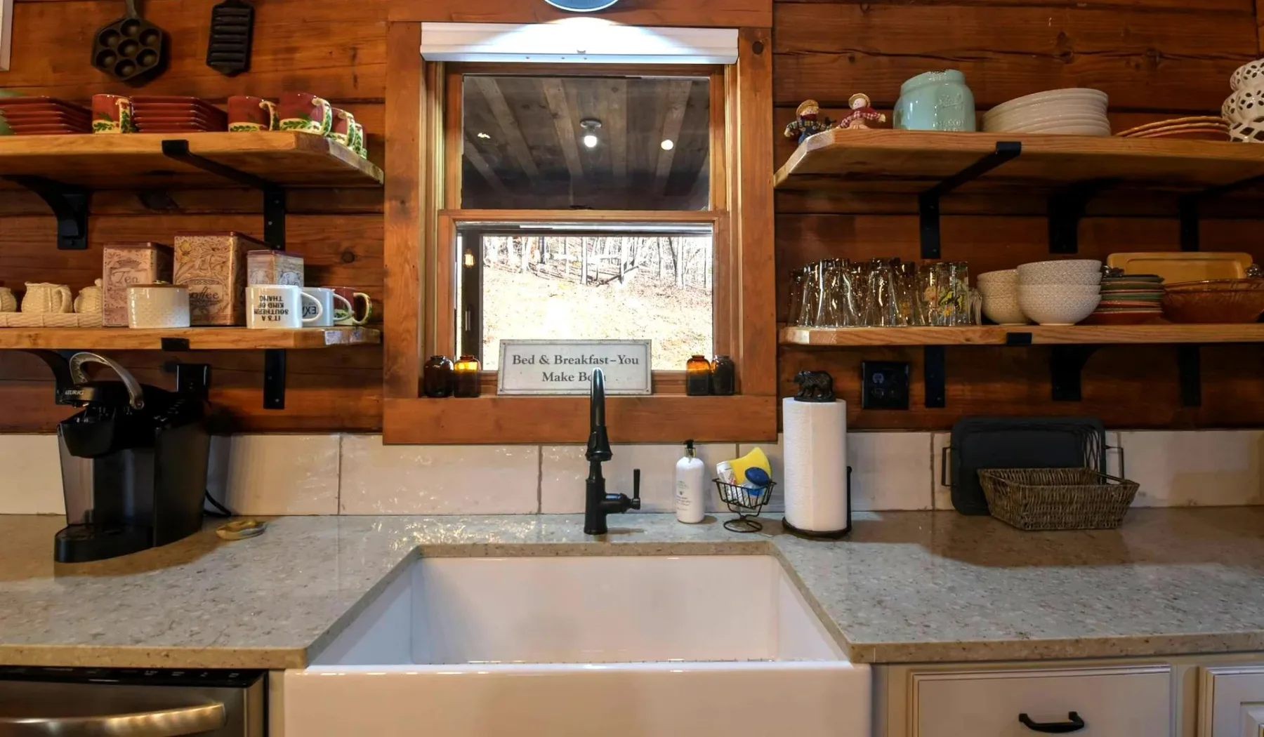 A rustic kitchen counter with a sink, coffee maker, and open shelves.