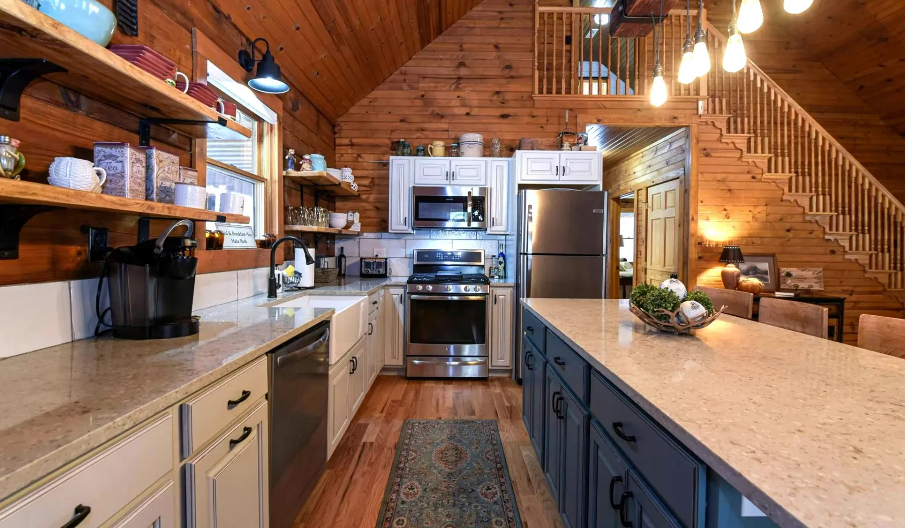 A spacious kitchen with a central island, stainless steel appliances, and wooden walls.