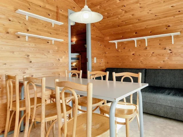 A dining area with a table and chairs beside a gray sofa.