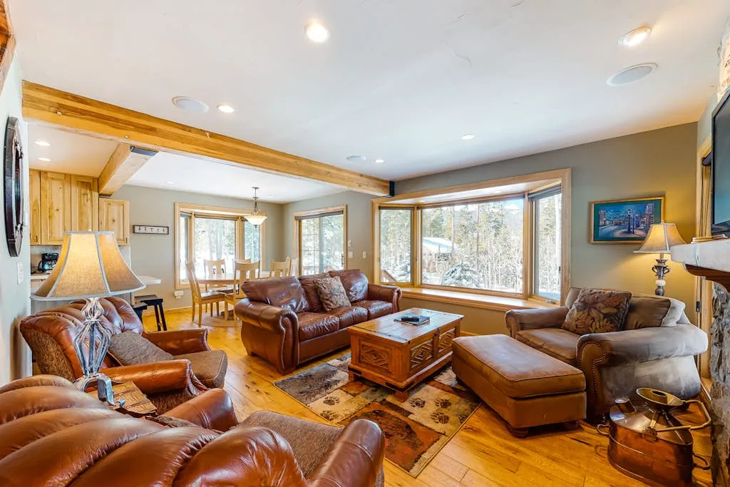 A spacious living room with seating arranged around a wooden coffee table.