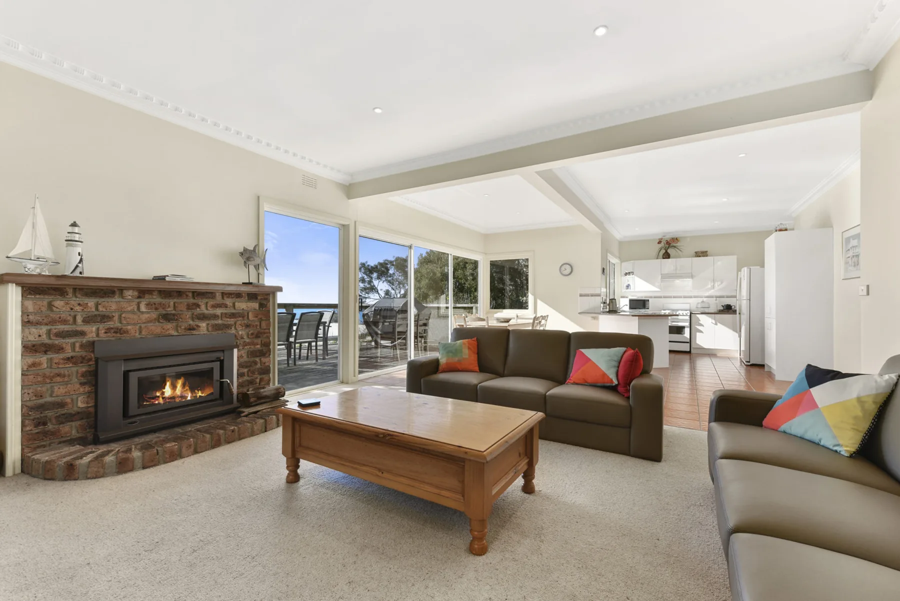 A living room with seating, a coffee table, and a brick fireplace.