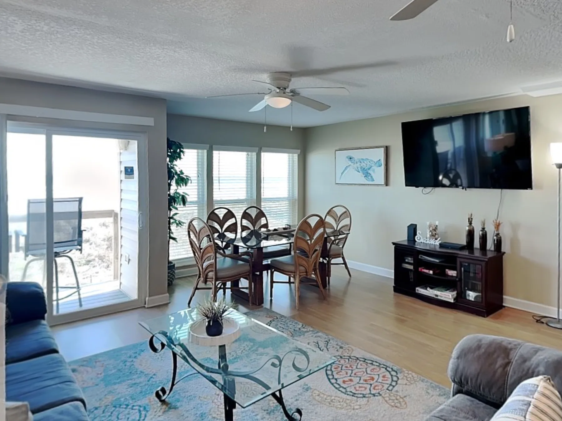 A living and dining area with a glass coffee table and a dining set.