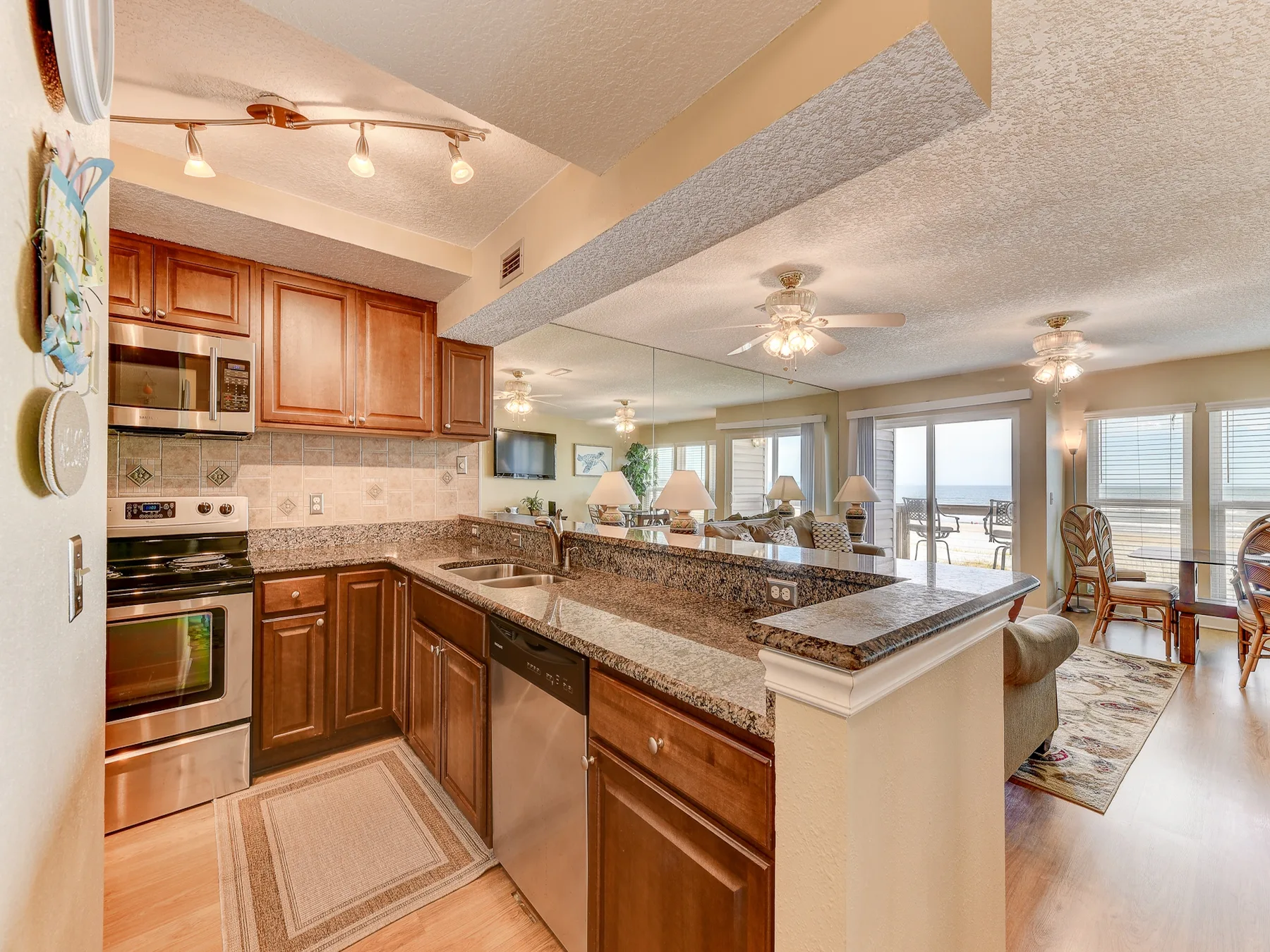 An open kitchen and dining area with a granite counter and large windows.