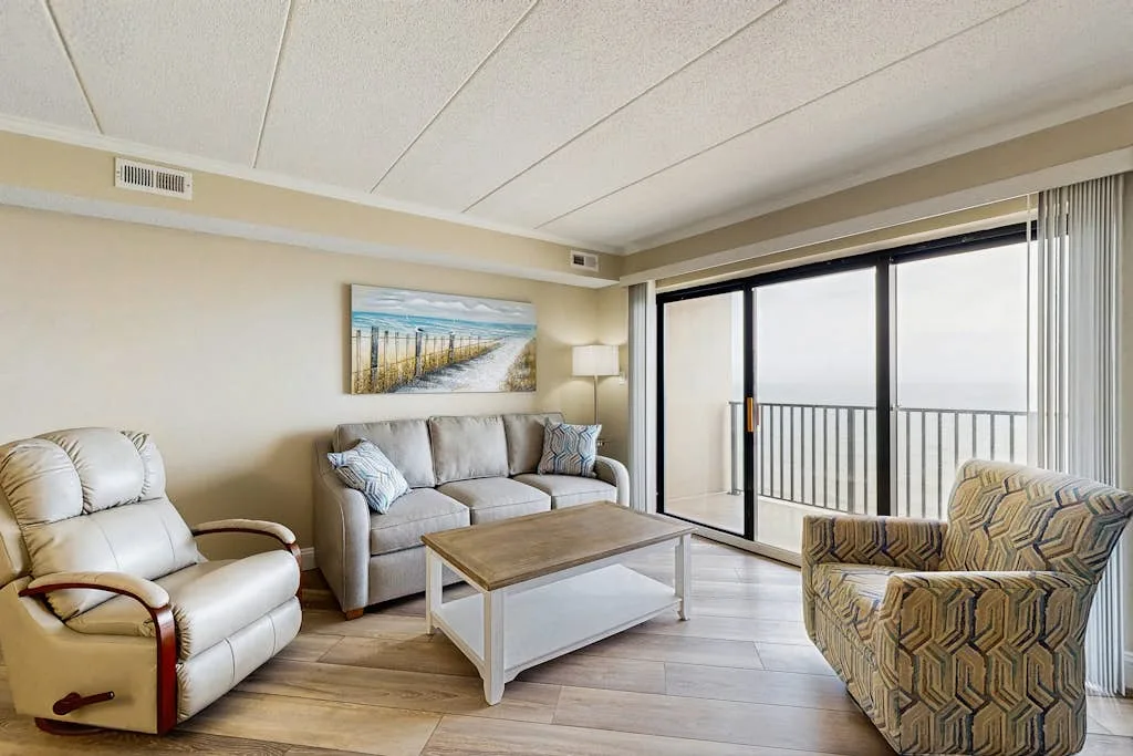 Living room with seating, a coffee table, and large windows.