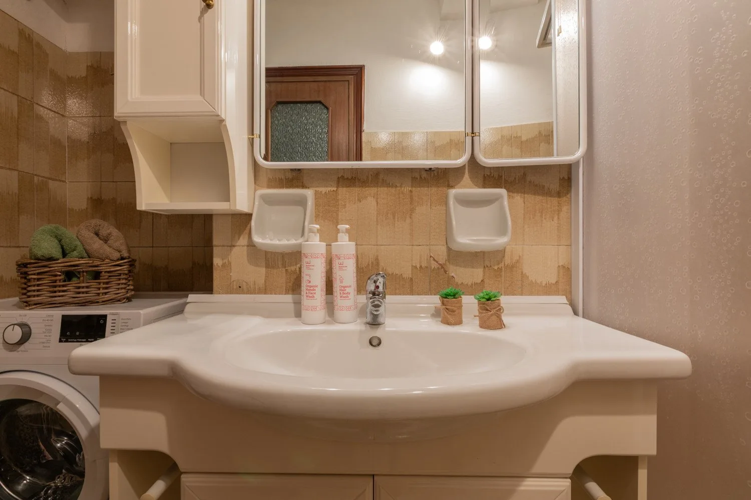 Un lavabo de baño con un fregadero amplio y armarios con espejo.