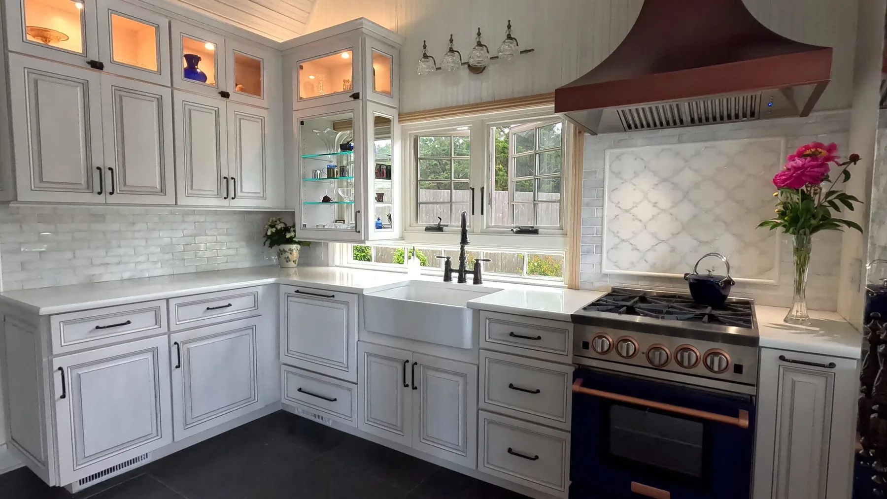 Una cocina luminosa con gabinetes claros, un fregadero central y una estufa.