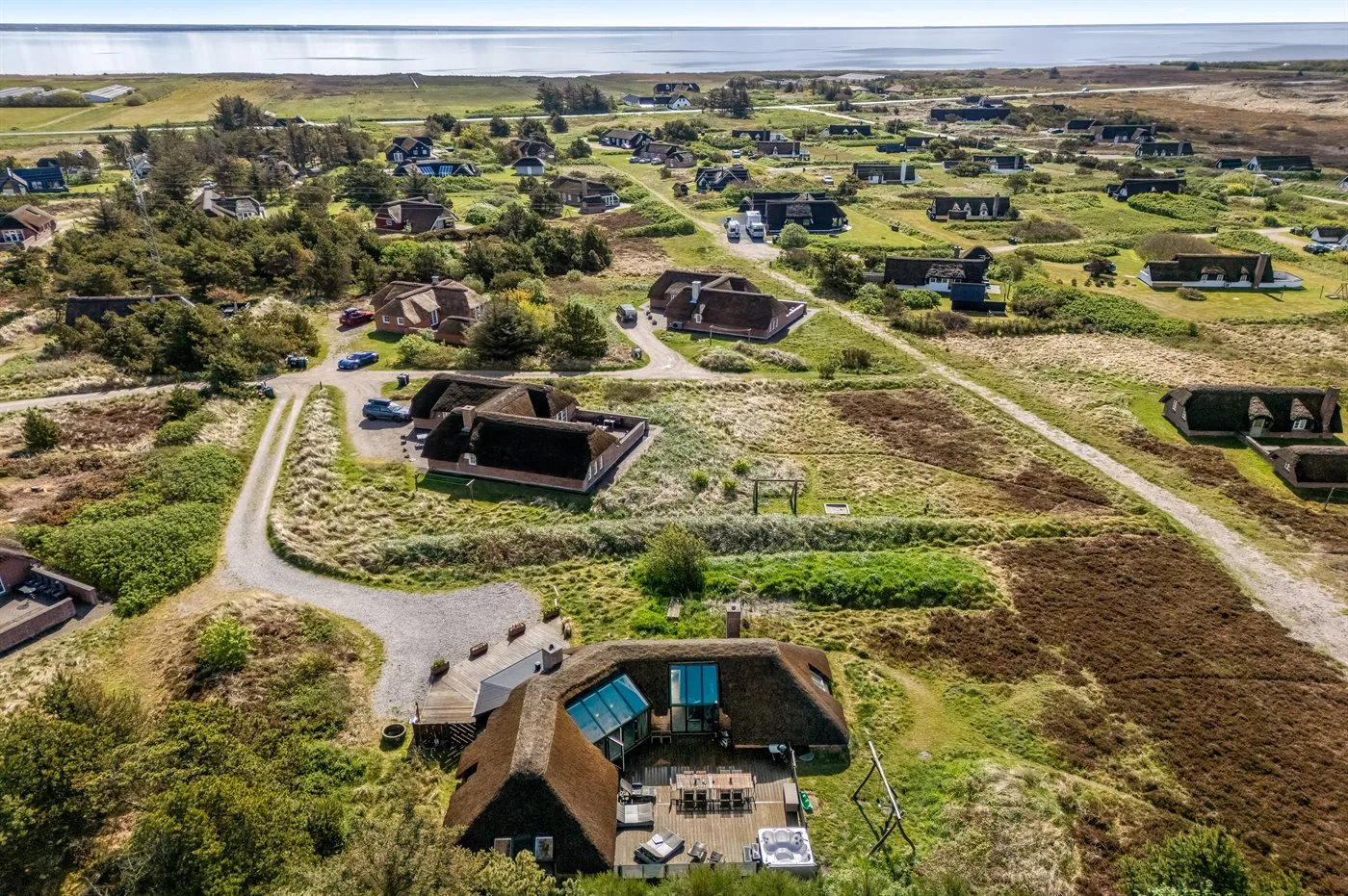 Vista aérea de edificios dispersos y caminos sinuosos en un paisaje verde.