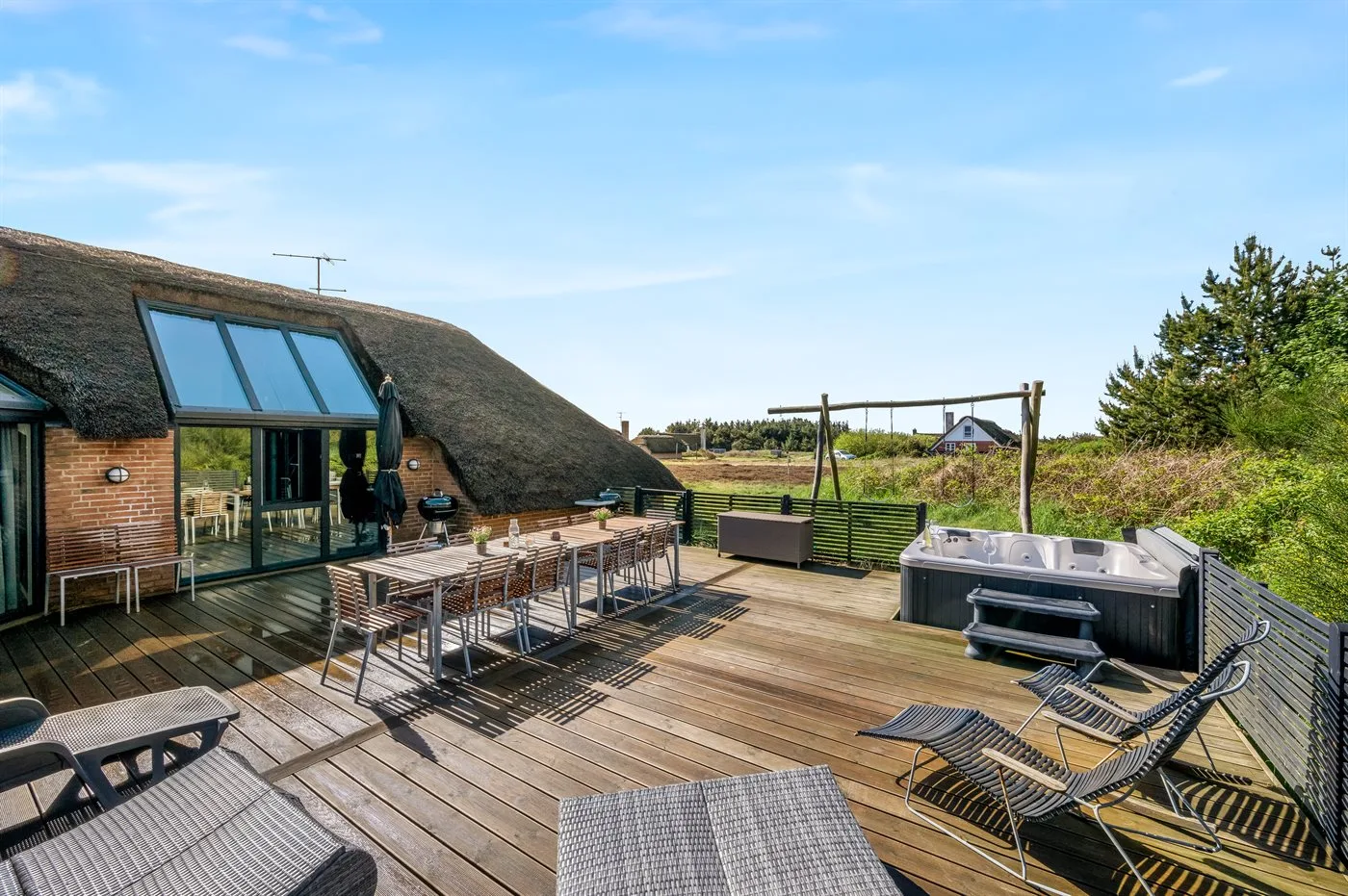 Terraza exterior con zona de comedor y bañera de hidromasaje.