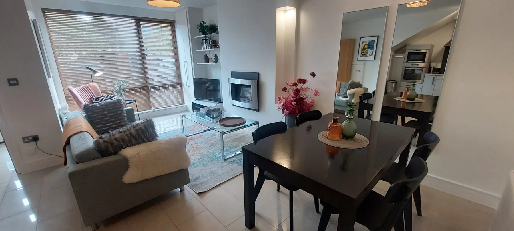 Una sala de estar y comedor con asientos junto a una ventana grande.