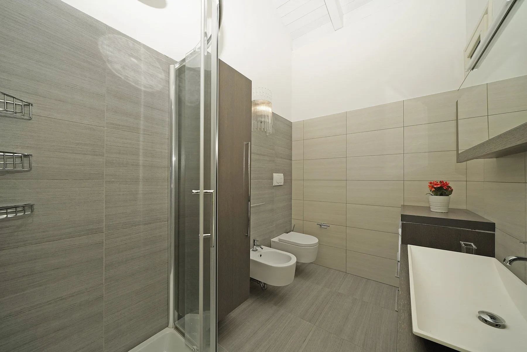 Un baño alicatado con ducha, inodoro, bidé y lavabo.