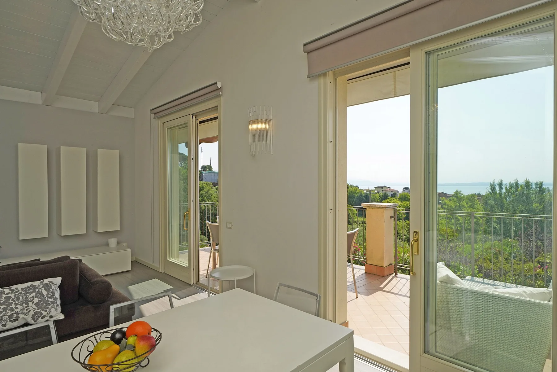Una luminosa sala de estar y comedor se abre a una terraza mediante grandes puertas de vidrio.