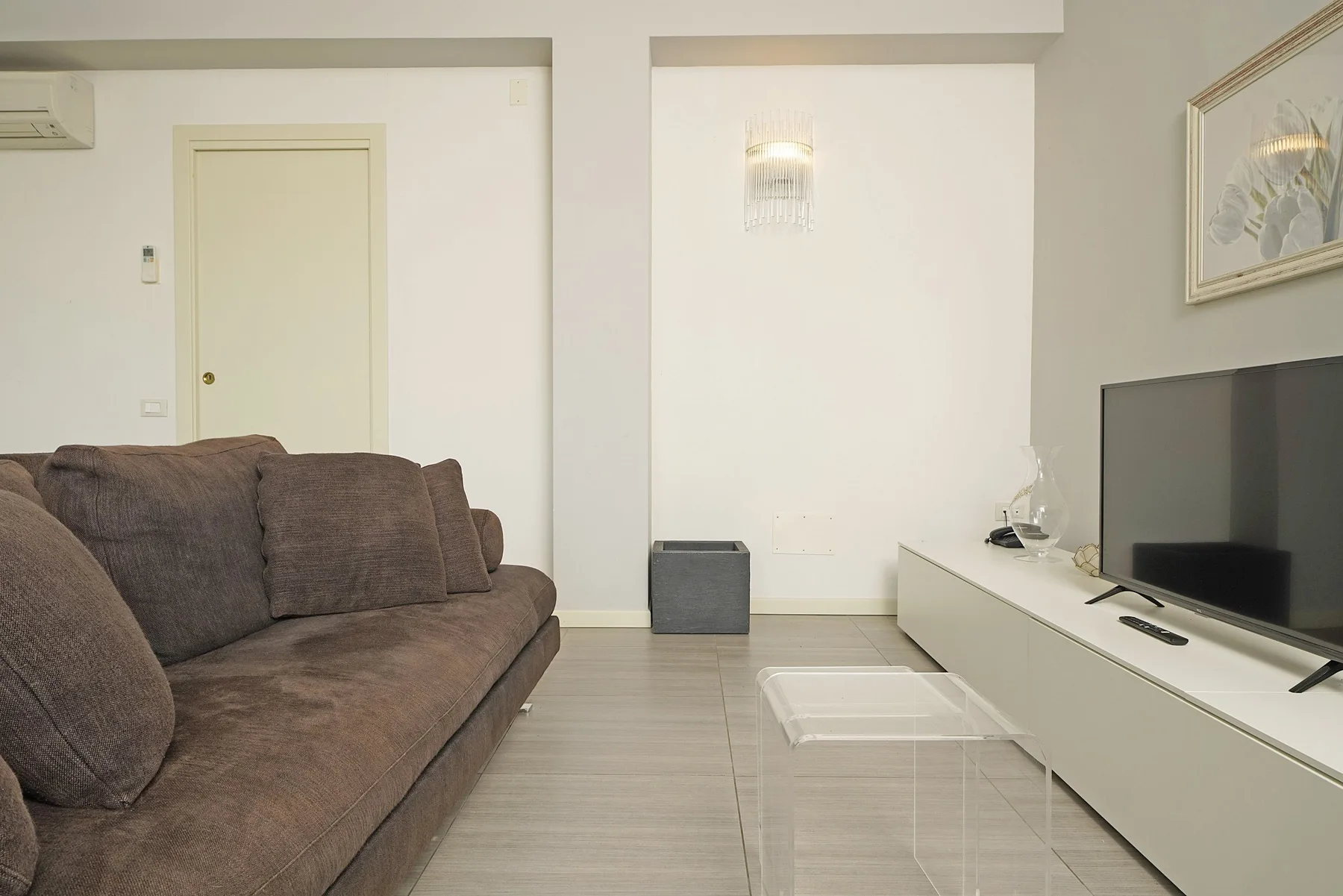 Una sala de estar con un sofá seccional y un televisor.